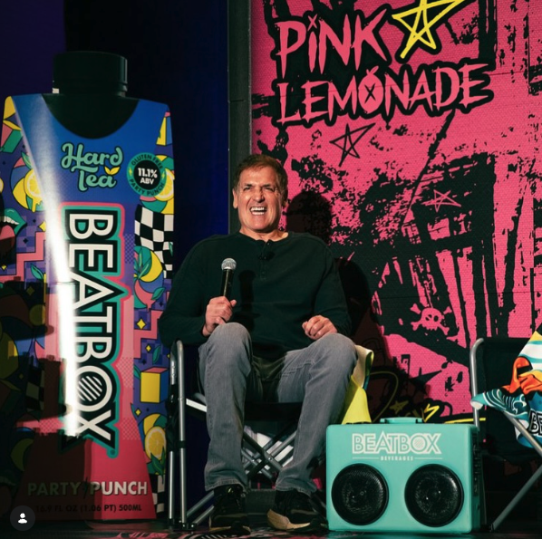 Mark Cuban on stage beside a branded speaker