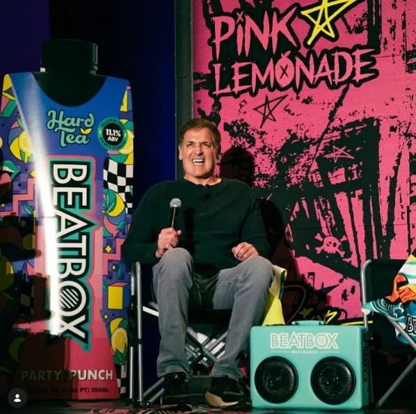 Mark Cuban on stage beside a branded speaker